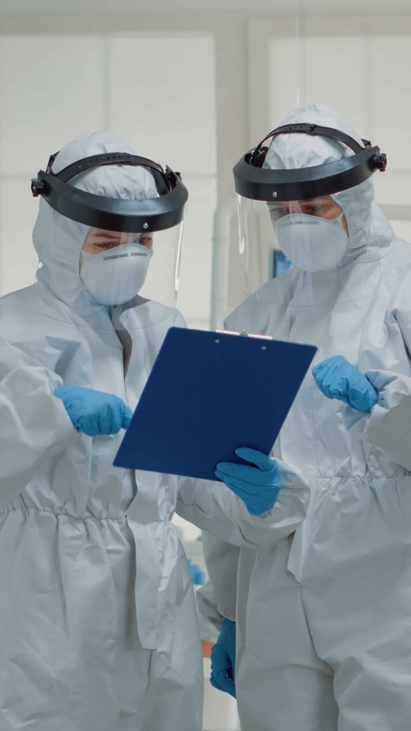 stomatology specialists talking about patient teeth healthcare while wearing protection suit against covid virus team dentists with face shield discussing dental operation clinic 2